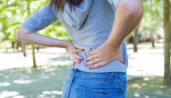 closeup-young-woman-touching-waist-park