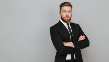 confident-young-businessman-suit-standing-with-arms-folded