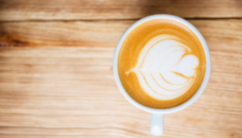 top-view-cup-with-cappucino-wooden-table